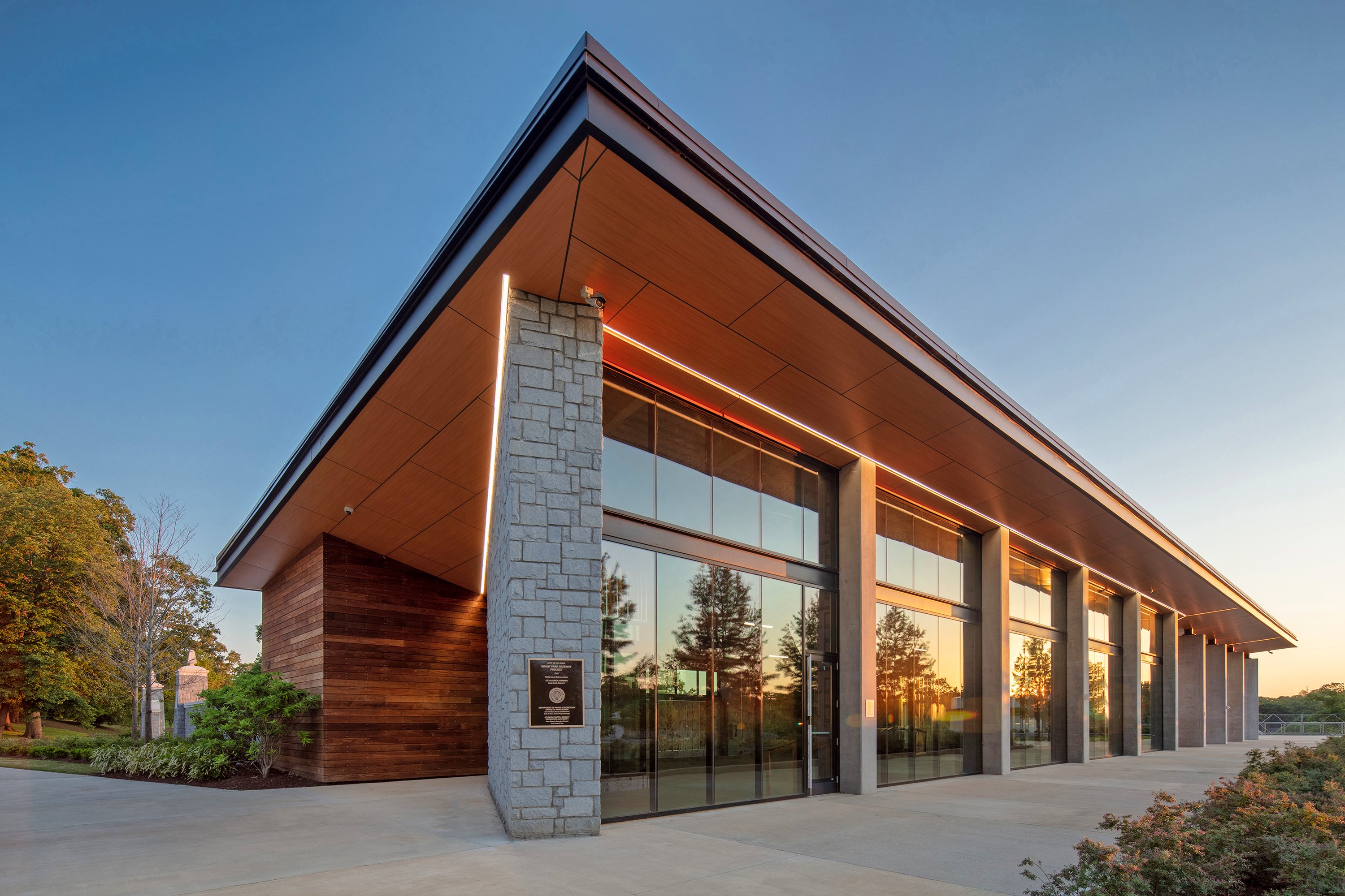 The Grant Park Gateway building at sunset, a modern pavilion of stone, wood, and glass.
